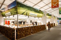 Innenaufnahme eines Messezeltes. Es ist ein Stand der LBV-Unternehmensgruppe zu sehen mit einer Holzumrandung und einem hinterleuchteten Banner.