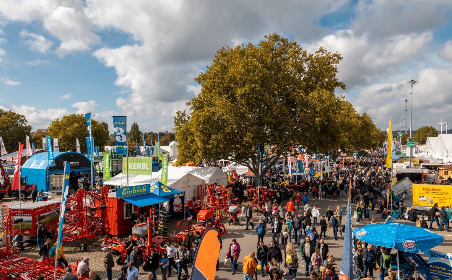 Besucher unter Bäumen Menschen flanieren unter Bäumen auf dem Gelände des Landwirtschaftlichen Hauptfests.